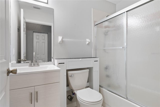 full bathroom with vanity, toilet, and bath / shower combo with glass door