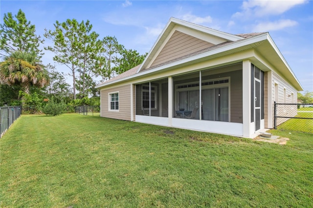 rear view of property with a yard and a sunroom