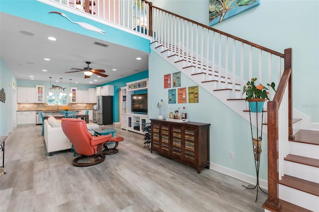 living room featuring sink, ceiling fan, and light hardwood / wood-style floors