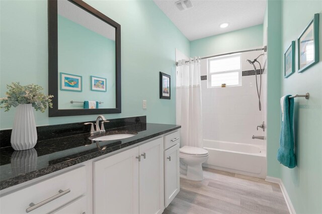 full bathroom with vanity, toilet, hardwood / wood-style flooring, and shower / bath combo with shower curtain