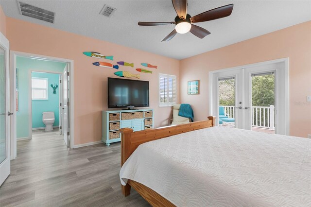 bedroom featuring access to outside, ensuite bath, ceiling fan, french doors, and hardwood / wood-style flooring