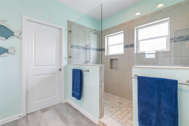 bathroom with hardwood / wood-style floors and tiled shower