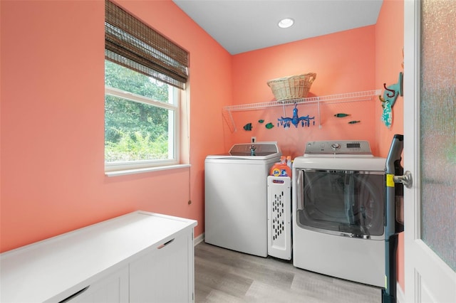 laundry area with light hardwood / wood-style floors and independent washer and dryer