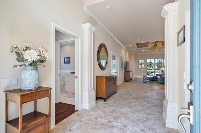 entrance foyer with crown molding and decorative columns