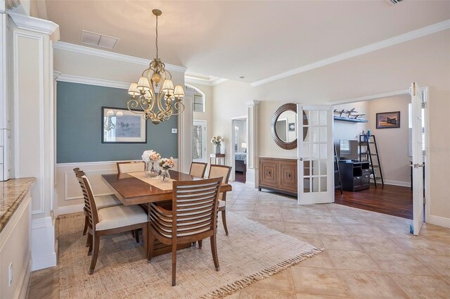 tiled dining room with crown molding and a chandelier