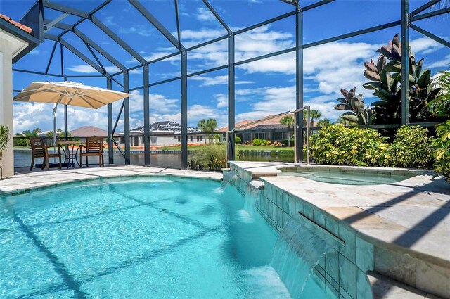 view of pool with glass enclosure, pool water feature, a patio, and a water view