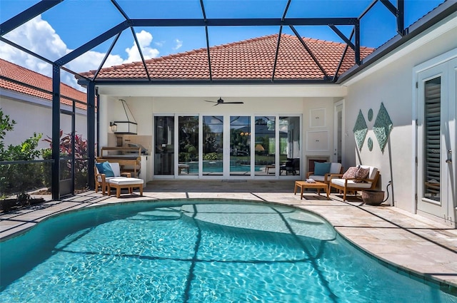 view of pool featuring a lanai, a patio area, outdoor lounge area, and ceiling fan