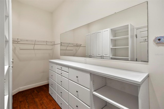 spacious closet with dark hardwood / wood-style flooring