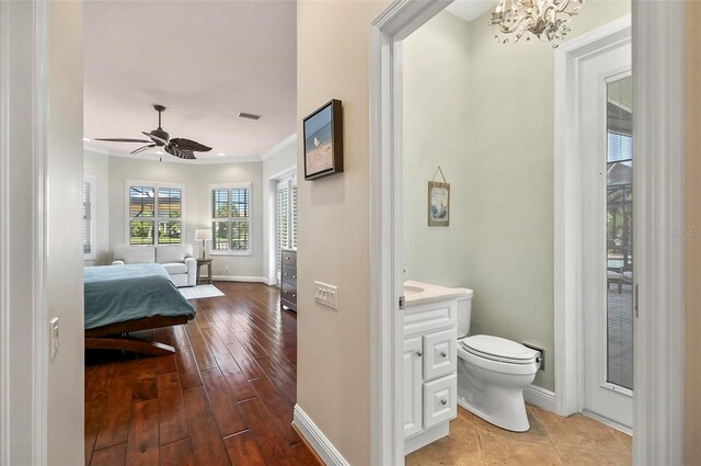 bathroom featuring vanity, ceiling fan with notable chandelier, crown molding, toilet, and hardwood / wood-style flooring