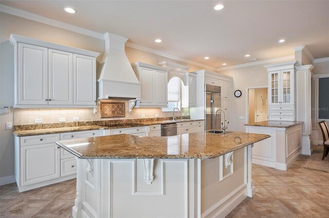 kitchen with an island with sink, appliances with stainless steel finishes, and white cabinets