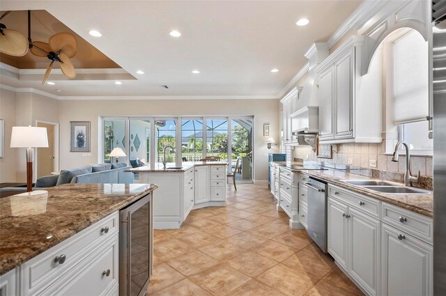 kitchen with tasteful backsplash, beverage cooler, sink, and white cabinets