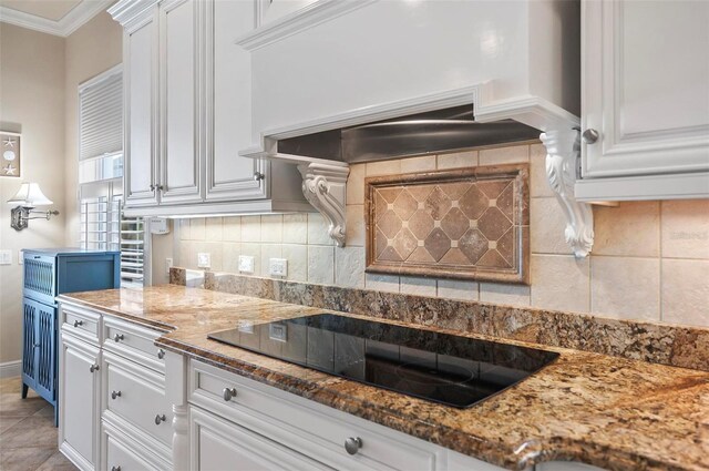 kitchen with ornamental molding, black electric cooktop, dark stone counters, and white cabinetry