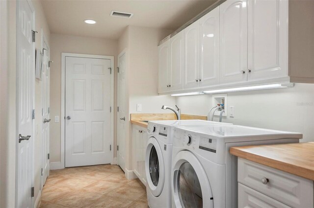 laundry area featuring washer and dryer, cabinets, sink, and light tile patterned flooring