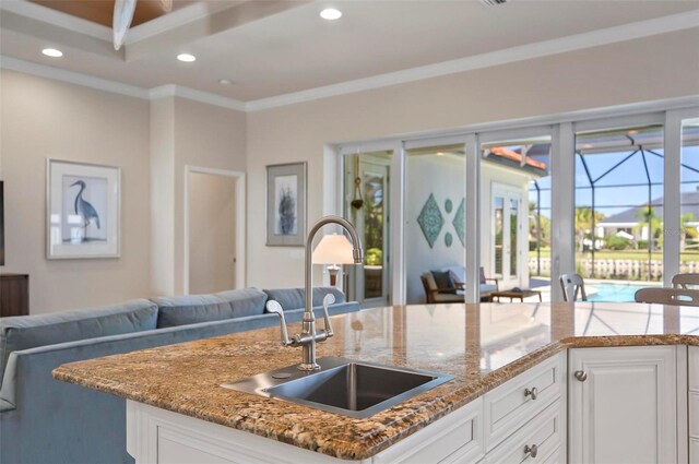 kitchen featuring ornamental molding, white cabinetry, sink, and stone counters