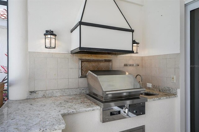 kitchen with light stone counters and tasteful backsplash