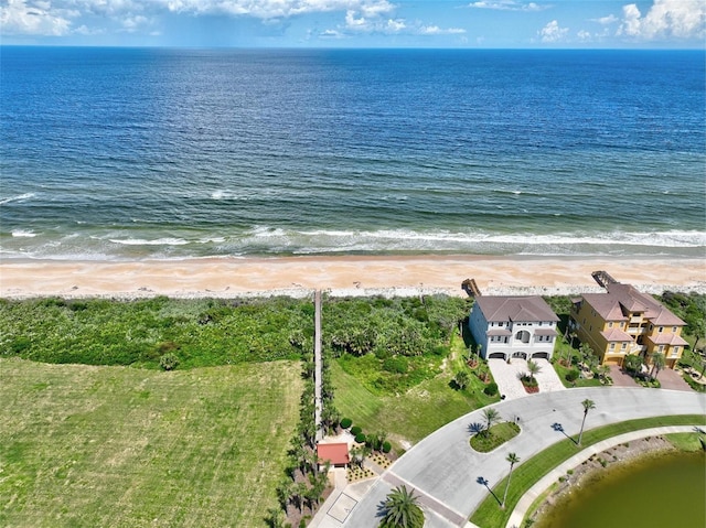 drone / aerial view featuring a water view and a view of the beach