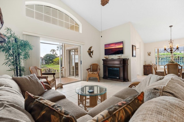 living room featuring high vaulted ceiling, an inviting chandelier, and light tile patterned flooring