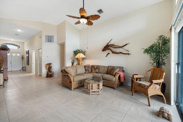 living room featuring lofted ceiling, light tile patterned flooring, and ceiling fan