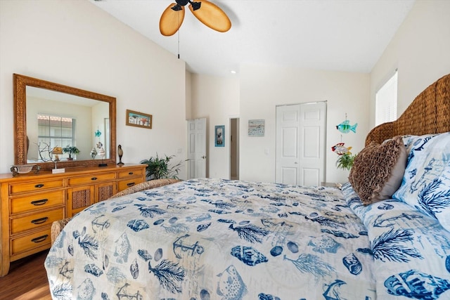 bedroom with high vaulted ceiling, hardwood / wood-style flooring, ceiling fan, and a closet