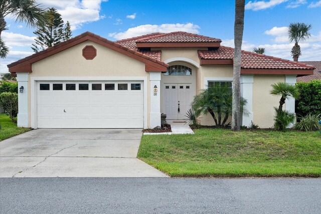 mediterranean / spanish-style house with a garage and a front yard