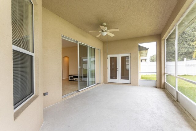 unfurnished sunroom with ceiling fan