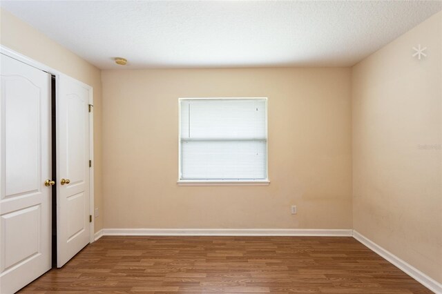 spare room featuring a textured ceiling and wood-type flooring