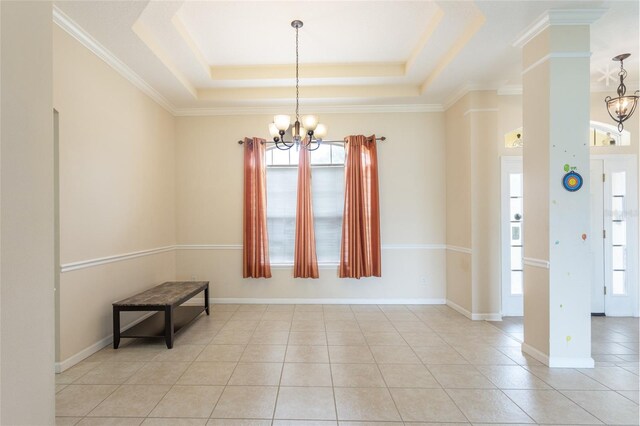 unfurnished dining area featuring crown molding, a raised ceiling, a wealth of natural light, and a chandelier