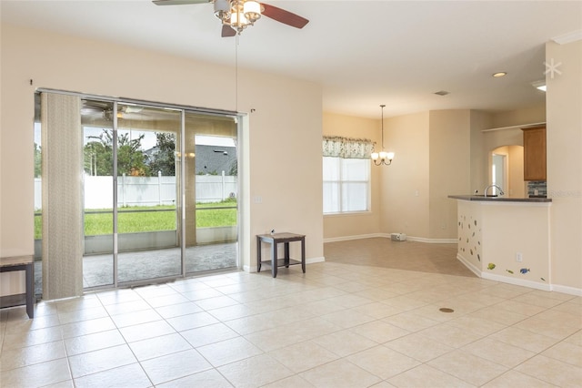 unfurnished living room with ceiling fan with notable chandelier and light tile patterned flooring