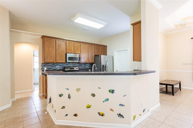 kitchen with light tile patterned floors, backsplash, appliances with stainless steel finishes, crown molding, and sink