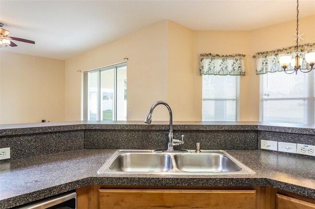 kitchen featuring decorative light fixtures, ceiling fan with notable chandelier, and sink