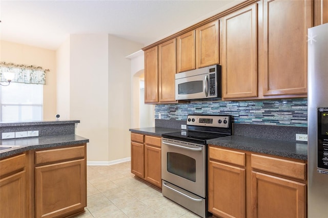 kitchen featuring light tile patterned floors, stainless steel appliances, and tasteful backsplash