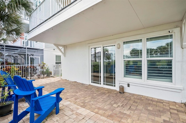 view of patio featuring a lanai and a balcony