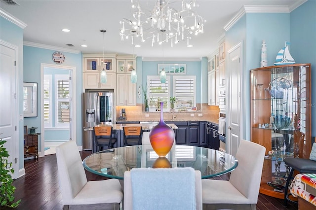 dining room with crown molding, sink, a chandelier, and dark hardwood / wood-style flooring