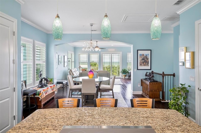 kitchen featuring crown molding, dark wood-type flooring, a healthy amount of sunlight, and light stone countertops