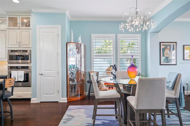 dining space featuring ornamental molding, a chandelier, and dark hardwood / wood-style flooring