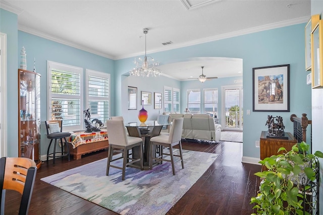 dining area with ceiling fan with notable chandelier, dark hardwood / wood-style flooring, and crown molding