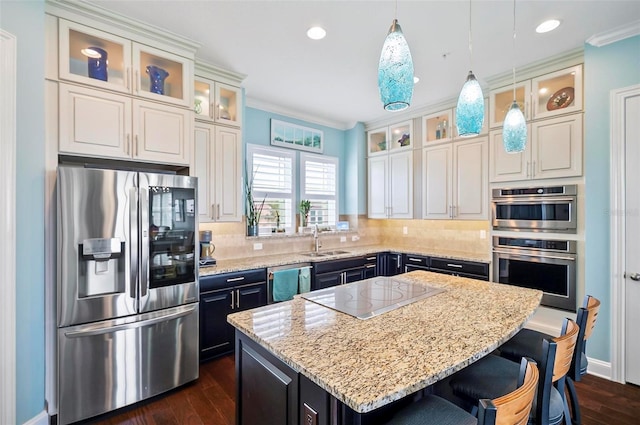 kitchen with a center island, decorative light fixtures, appliances with stainless steel finishes, and white cabinetry