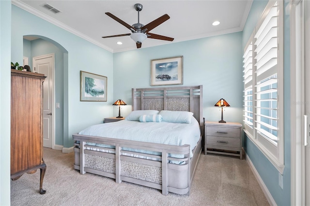 carpeted bedroom featuring ceiling fan and crown molding