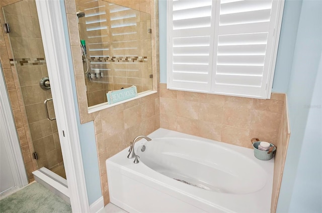 bathroom featuring shower with separate bathtub