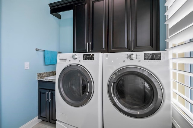 laundry area with light tile patterned flooring, cabinets, and separate washer and dryer