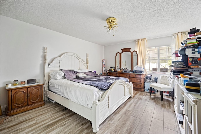 bedroom featuring light hardwood / wood-style floors and a textured ceiling