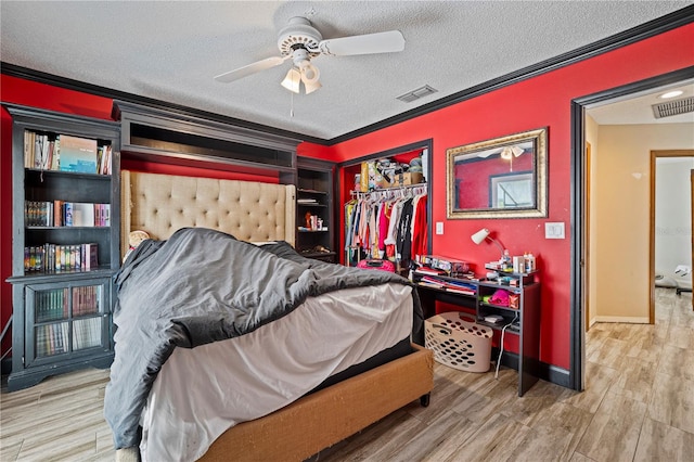 bedroom featuring hardwood / wood-style flooring, crown molding, a closet, ceiling fan, and a textured ceiling