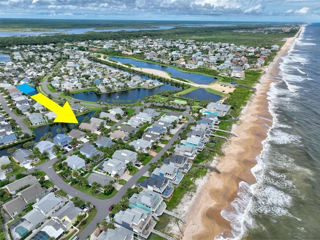 birds eye view of property featuring a beach view and a water view