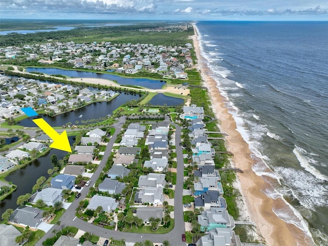 drone / aerial view featuring a water view and a view of the beach