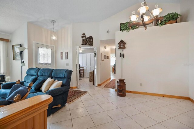 living room with a textured ceiling, high vaulted ceiling, light tile patterned floors, and a notable chandelier