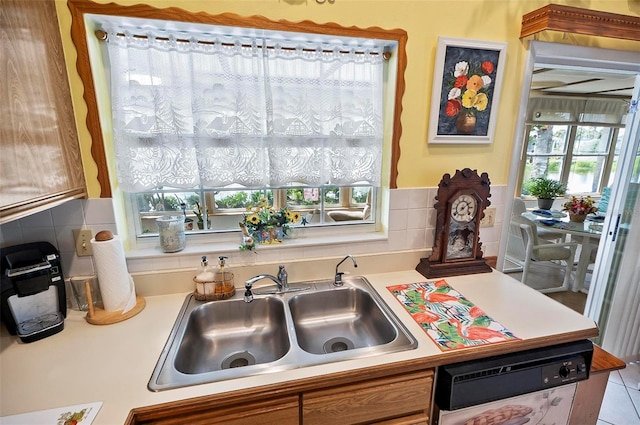 8 Sea Vista Dr, Palm Coast, FL 32137 - kitchen with light countertops, a sink, dishwashing machine, brown cabinetry, and decorative backsplash
