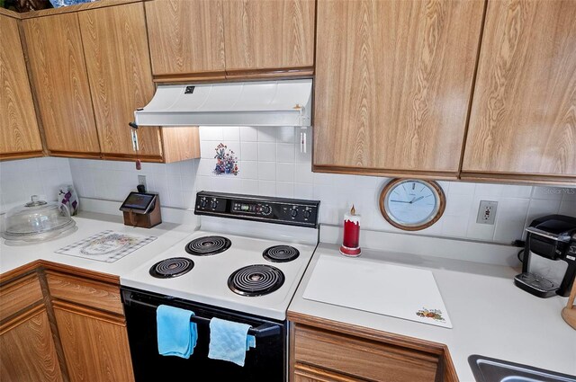 kitchen with range hood, white electric stove, and decorative backsplash