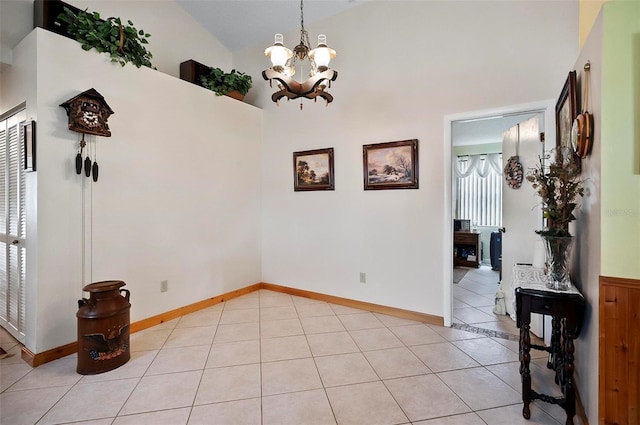 dining space featuring light tile patterned floors, a wealth of natural light, an inviting chandelier, and vaulted ceiling