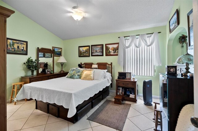 tiled bedroom with lofted ceiling, ceiling fan, and a textured ceiling