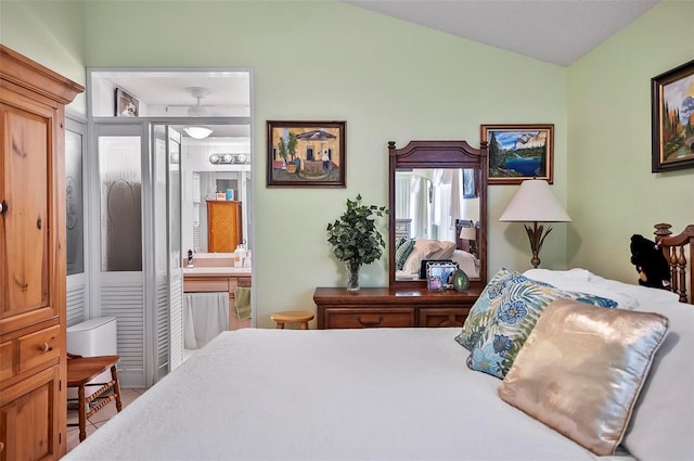 bedroom with connected bathroom and vaulted ceiling